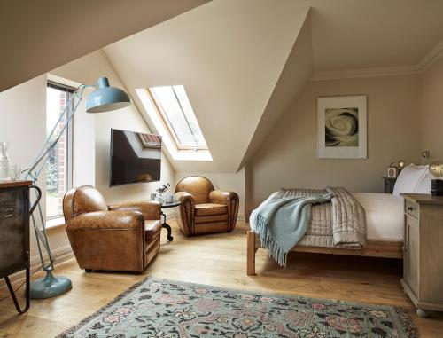 a bedroom with a bed and two chairs at The Harper in Langham