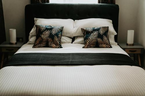 a bed with three pillows on it with two candles at Retreat on the Green in Holt