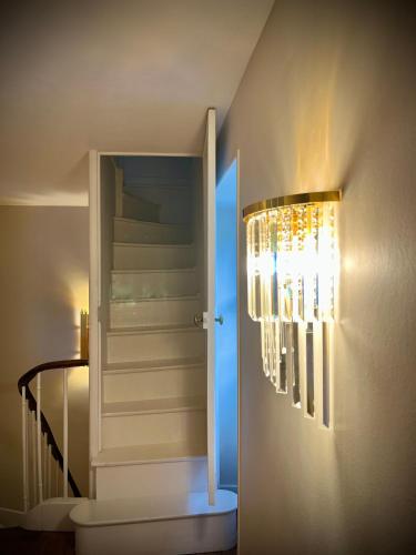 a staircase with a chandelier next to a stair case at Richard Lequet Domaine gastronomique du Val d Atur in Boulazac