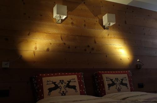 a bedroom with two beds and two pictures on the wall at Baita Filomena in Livigno