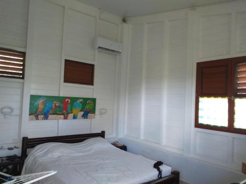 sypialnia z łóżkiem w białym pokoju w obiekcie Bungalow Ti Bois w mieście Belle Languette