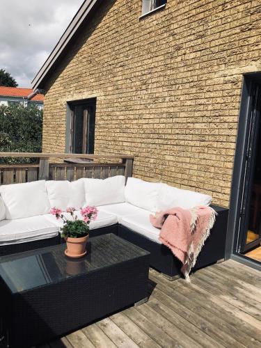un sofá blanco sentado en un patio con una mesa en Lägenhet nära hav och centrum en Halmstad