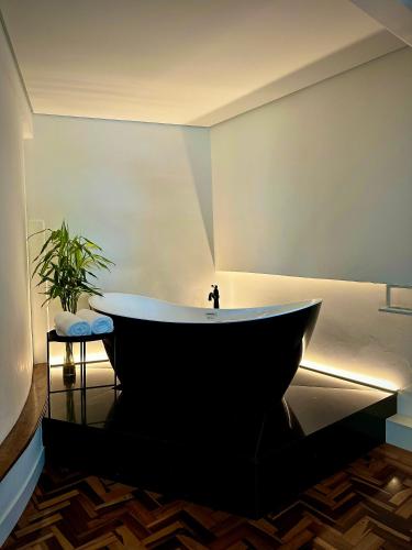 eine Badewanne in einem Zimmer mit Pflanze in der Unterkunft Estúdio 196 in Bento Gonçalves