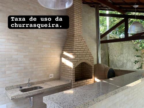 una pared de ladrillo con fregadero y un horno de ladrillo en Pousada Dunas Do Peró, en Cabo Frío