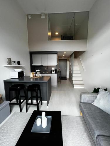Il comprend un salon et une cuisine avec un canapé et une table. dans l'établissement Penthouse Loft - Near the Airport, à Vantaa
