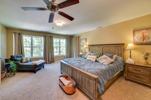 a bedroom with a large bed and a ceiling fan at Lakefront Gilbertville Haven with Private Boat Dock! in Gilbertsville