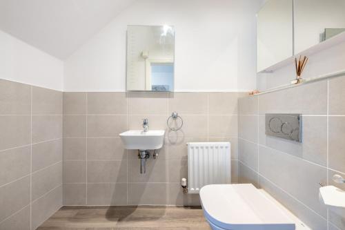 3 bedroom house in Bricketwood St Albans في Garston: حمام مع حوض ومرحاض