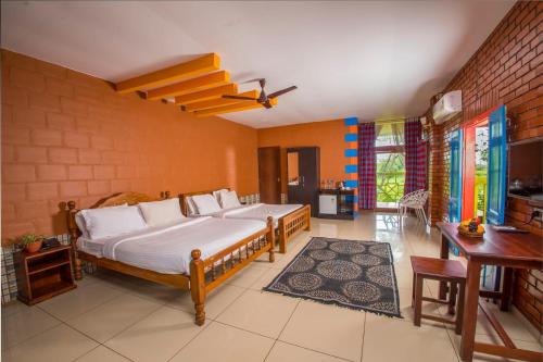 a bedroom with a large bed in a room with a table at Woodgreens Heritage Resorts in Kannur
