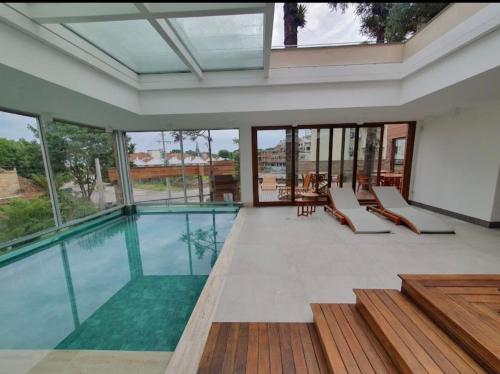 a swimming pool in a house with glass walls at Canela Cantinho dos Sonhos in Canela