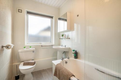 a bathroom with a toilet and a sink and a shower at 2 Bed Bungalow - Free Parking 