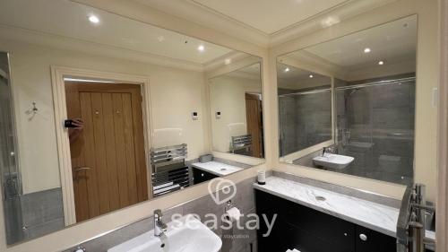 ein Badezimmer mit zwei Waschbecken und einem großen Spiegel in der Unterkunft Myrtles Barn Amazing Renovated 2 Bed No Guest Fee in Kent