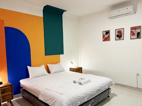 a bedroom with a bed with a colorful wall at Villaok in Kuta