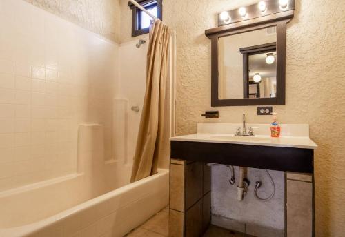 ein Badezimmer mit einem Waschbecken, einer Badewanne und einem Spiegel in der Unterkunft La Hacienda San Felipe Condo 18 in San Felipe
