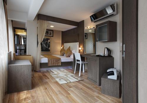 イスタンブールにあるジャズ ホテル ニサンタシェのベッドとデスクが備わるホテルルームです。