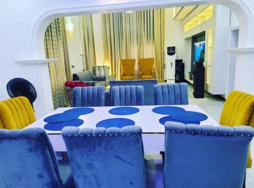 uma sala de conferências com uma mesa e cadeiras azuis em Luxurythemain em Ibadan