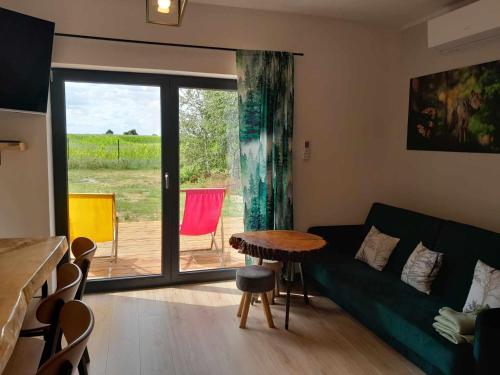 a living room with a green couch and a table at Przystanek Las in Gąsawa