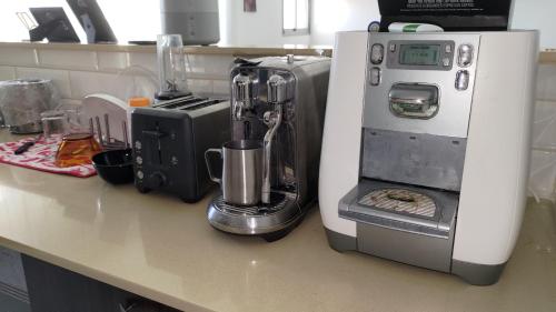 a kitchen counter with a coffee maker next to a coffee maker at Green Park in H̱adera