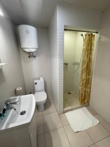 a bathroom with a shower and a toilet and a sink at Спортохота in Cherkasy