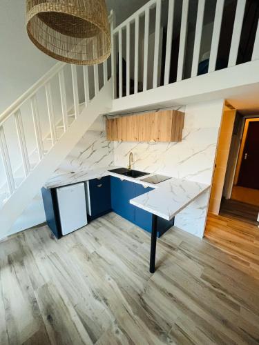 une cuisine avec un évier et un escalier dans l'établissement Duplex Climatisé Cadre Royal, à Sète