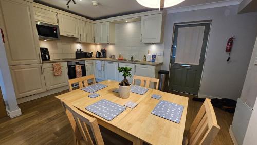 a kitchen with a wooden table with chairs and a table sidx sidx sidx at Castle Pond House in Pembroke