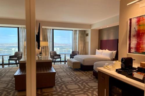 a hotel room with a bed and a table and chairs at Elegant Stay at Resorts World Strip Las Vegas in Las Vegas