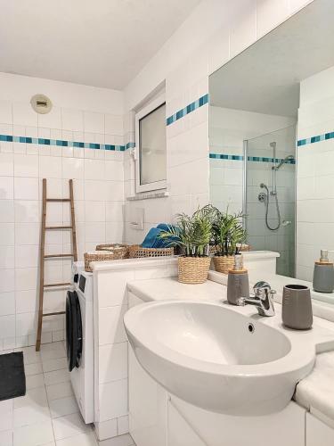 une salle de bain blanche avec un lavabo et une douche dans l'établissement Superbe appartement avec Jardin, à Villeneuve-Loubet