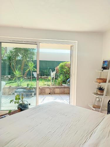 une chambre avec un lit et une porte coulissante en verre dans l'établissement Superbe appartement avec Jardin, à Villeneuve-Loubet