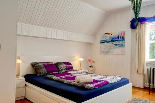 ein Schlafzimmer mit einem großen Bett mit violetter Bettwäsche in der Unterkunft Wohnung am Bergpark Wilhelmshöhe in Kassel