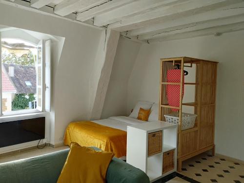 1 dormitorio pequeño con 1 cama y TV en Atypique Logement Central, en Arpajon