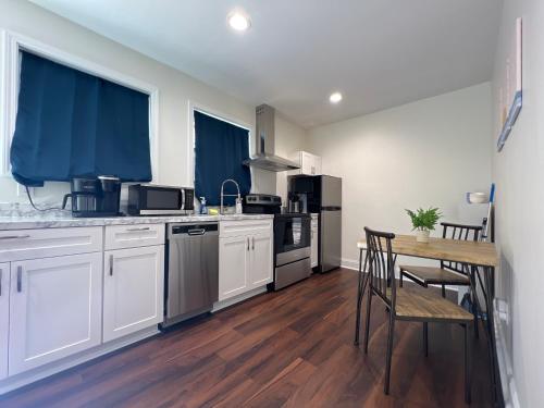 une cuisine avec des placards blancs et une table avec des chaises dans l'établissement 1BR Fully Handicap Accessible Near Downtown, à Greenville