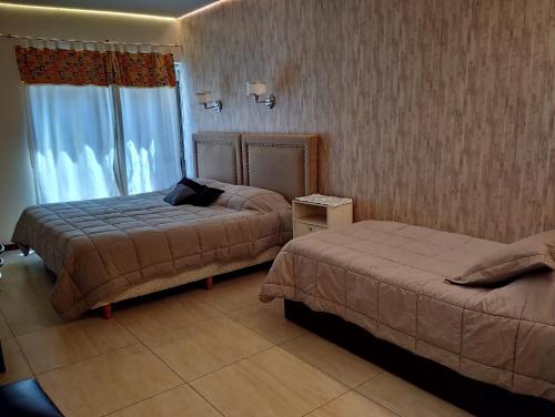 a hotel room with two beds and a window at Microcentro y Obelisco in Buenos Aires