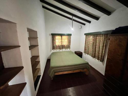ein Schlafzimmer mit einem grünen Bett und einem Fenster in der Unterkunft El vallecito in La Ramada