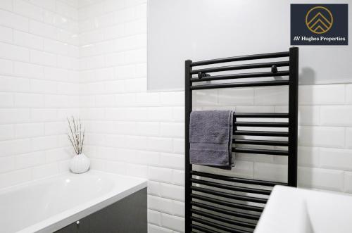 a bathroom with a towel rack next to a sink at Spacious House by AV Hughes Properties Short Lets & Serviced Accommodation Northampton with Free Parking & Fast Wi-Fi in Kingsthorpe