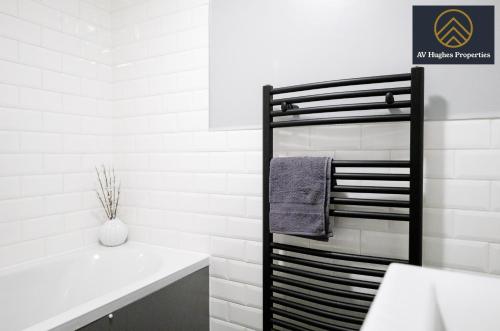 a bathroom with a towel rack next to a sink at Two Bedroom House by AV Hughes Properties Short Lets & Serviced Accommodation Northampton - Modern & Spacious with Fast Wi-Fi & Free Parking in Kingsthorpe