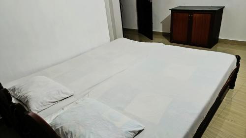 1 cama blanca grande con 2 almohadas en Juliet's Homestay en Kochi