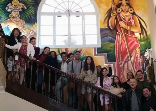 a group of people standing on a staircase in front of a mural at Hotel Boutique Spa Villa de Sant in Quito