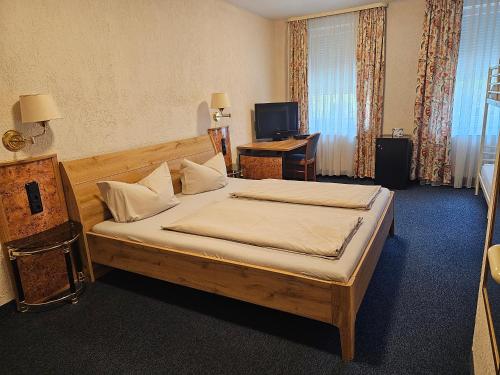 um quarto com uma cama e uma secretária. em Hotel City Faber em Worms