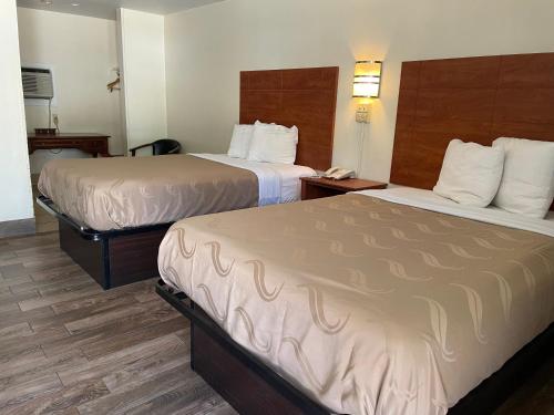 a hotel room with two beds and a phone at Evergreen Inn and R.V. in Winnfield