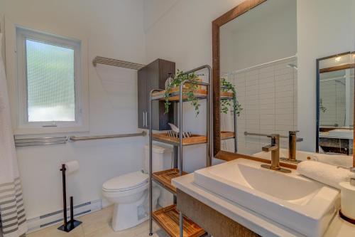 W łazience znajduje się umywalka, toaleta i lustro. w obiekcie Chalet Orkidea w mieście Chertsey
