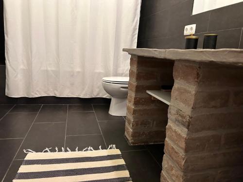a bathroom with a white shower curtain and a toilet at Monte de Santa Maria in Monsaraz