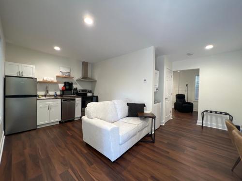 a living room with a white couch and a kitchen at 1BR Near Downtown & Mountain Goat Coffee in Greenville