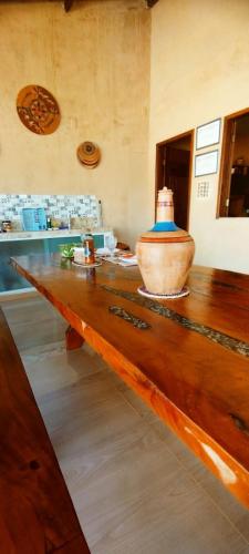 Camassari的住宿－Casa mãe Terra，一张大花瓶,坐在木桌前