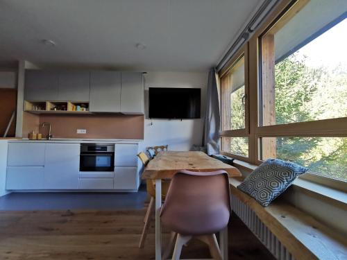 a kitchen with a wooden table and a dining room at A 2 passi dagli impianti in Mezzana