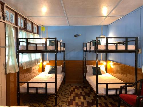 a room with three bunk beds in it at Solo Stays - Backpacker hostel in Darjeeling