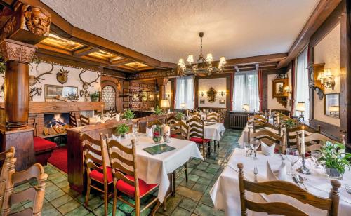 a restaurant with tables and chairs and a fireplace at Hotel Krone in Rielasingen-Worblingen