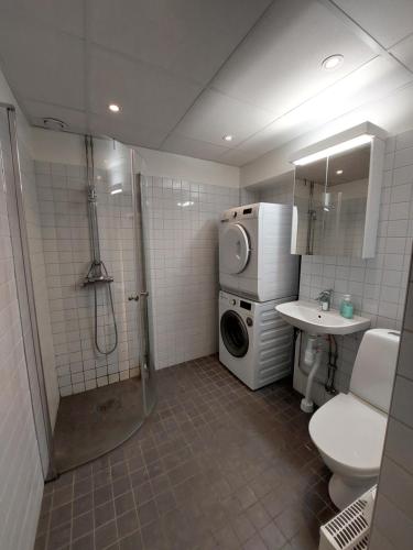 a bathroom with a shower and a toilet and a sink at Home Inn MRT19 in Stockholm