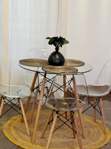 a glass table with a vase on it with two chairs at Modernes Loft mit Whirlpool, Sauna & Billardtisch in Essen