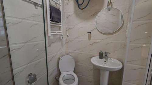 a bathroom with a toilet and a sink and a mirror at Big studio apt.on Liberty Square in Tbilisi City