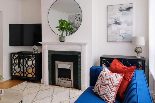 a living room with a blue couch and a mirror at London South Kensington mews house near Natural History Museum and tube in London