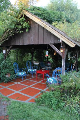 un patio con sillas azules y una mesa roja en Posada de la Rosarito en Brandsen